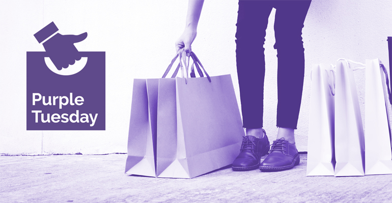 Woman carrying a number of shopping bags, and the Purple Tuesday logo.